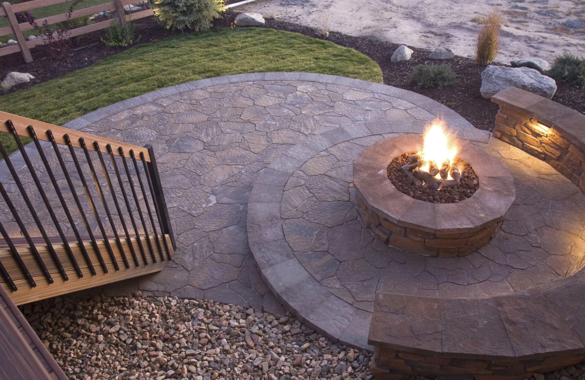 Outdoor fire pit feature integrated into a masonry patio